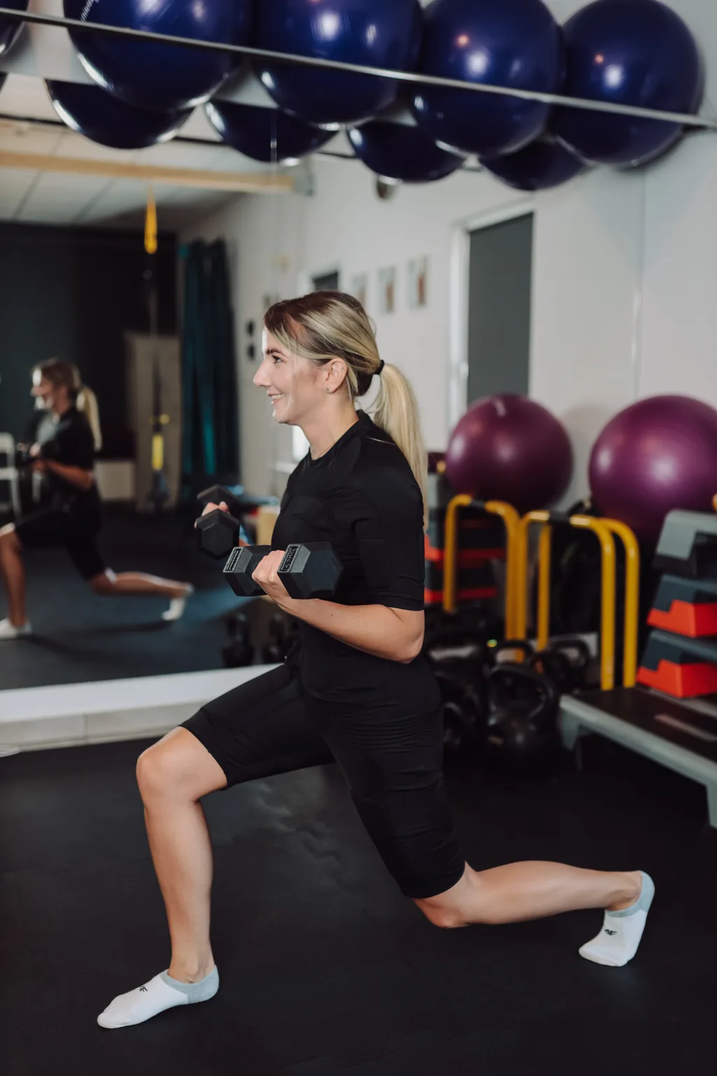 Trening EMS w ME Studio Chrzanów — ćwiczenie z hantlą w stroju z elektrodami